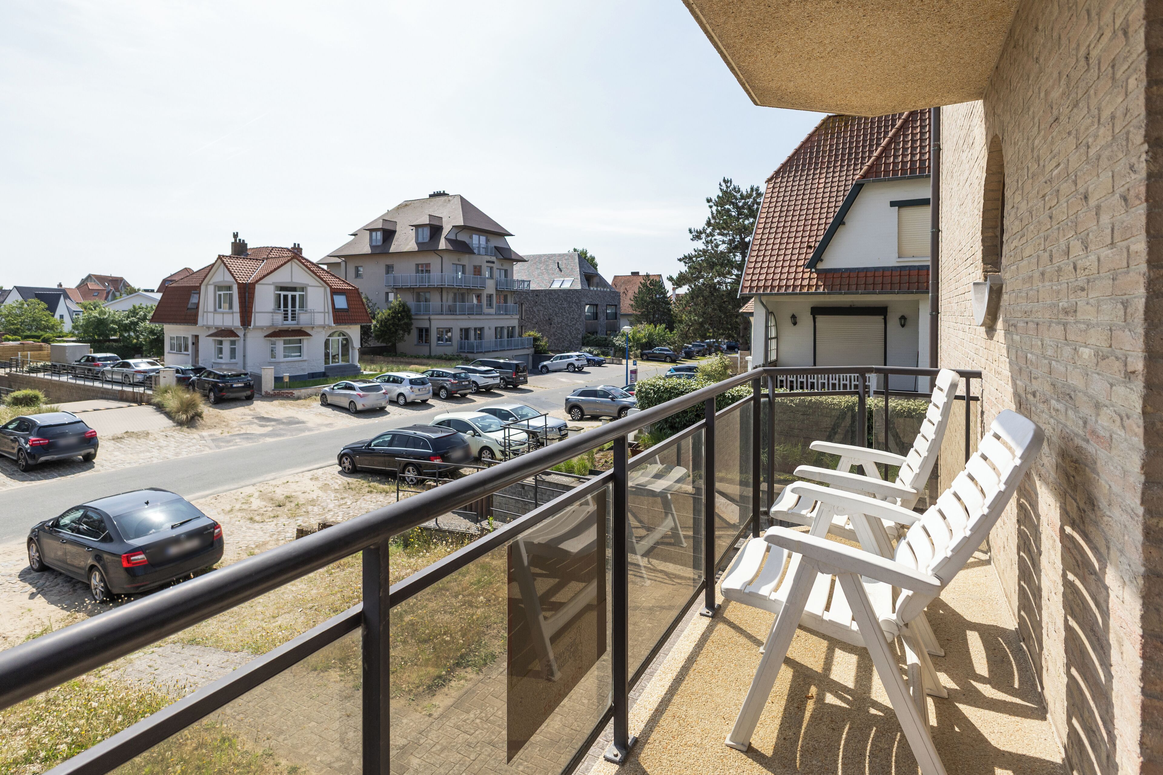 Ein Balkon mit Blick auf einen Parkplatz und Gebäude.