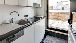 A compact kitchen with a sink, stove, and dishwasher. - Gouden Boom 0618 + P* (Koksijde)