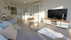 A modern living room with a sofa, coffee table, and TV stand.