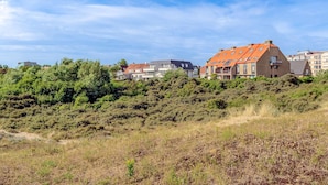 A residential area with modern houses, some with sloped roofs and others with flat roofs, surrounded by greenery and a clear sky. - 2 bedroom accommodation in Koksijde (Koksijde)