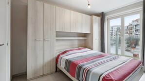 Una camera da letto con un letto, un armadio e vista all'esterno.