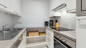 Una cucina moderna con mobili bianchi, elettrodomestici in acciaio inossidabile e forno integrato.