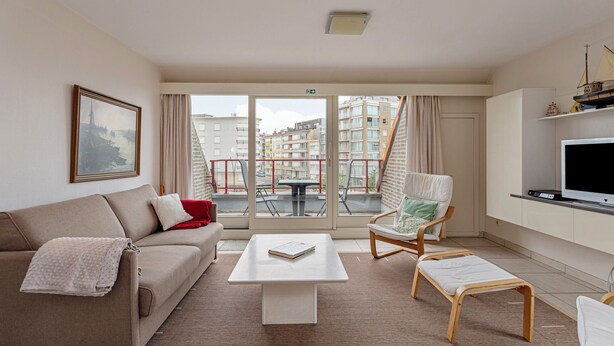 A modern living room with a sofa, a coffee table, a chair, and a TV. - ZeeZonZand C-0206 + G* (Koksijde)