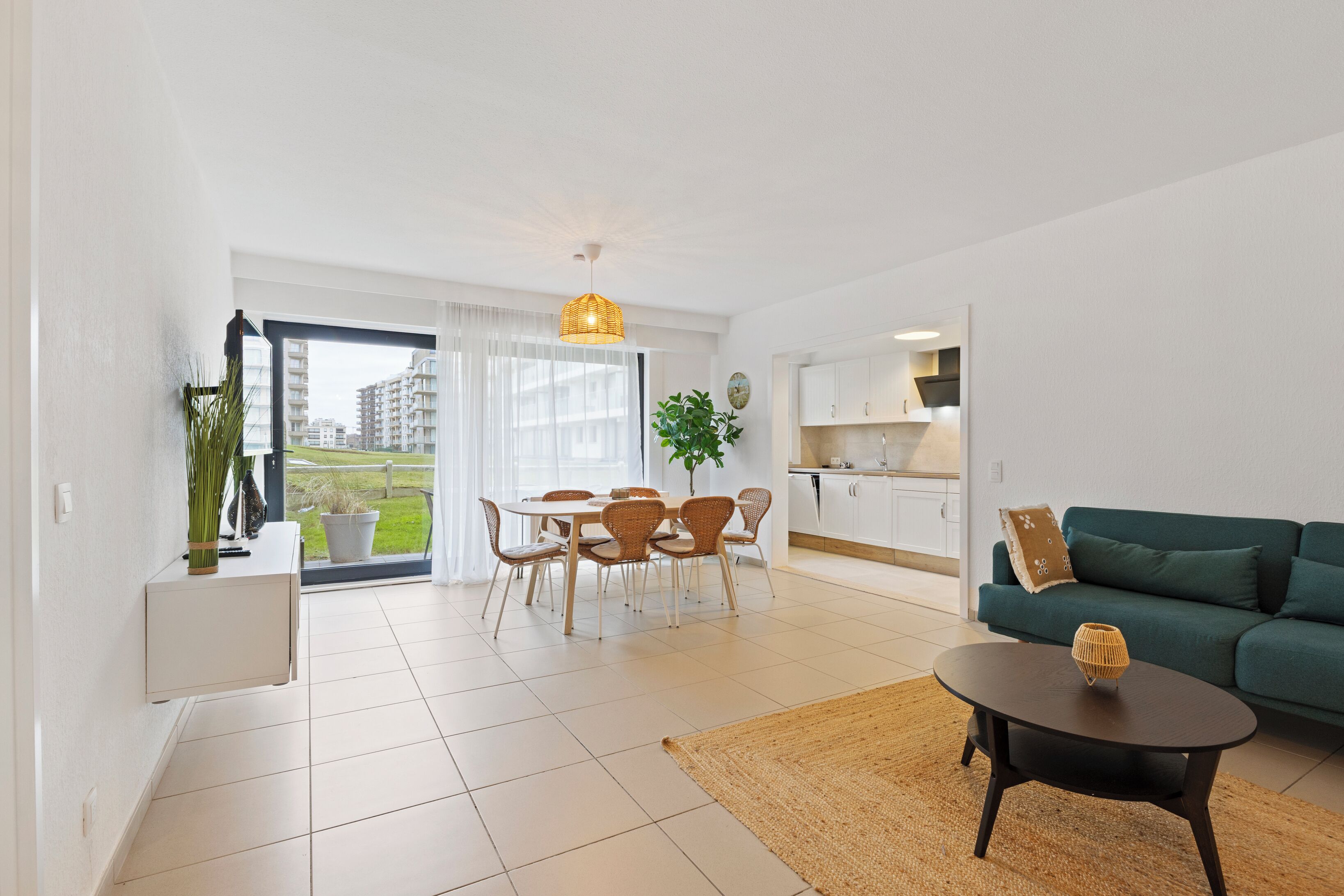 Un appartement moderne comprenant un coin repas, une cuisine et un salon.