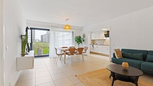 A modern apartment with a dining area, kitchen, and living room. - 1 bedroom accommodation in De Panne (De Panne)