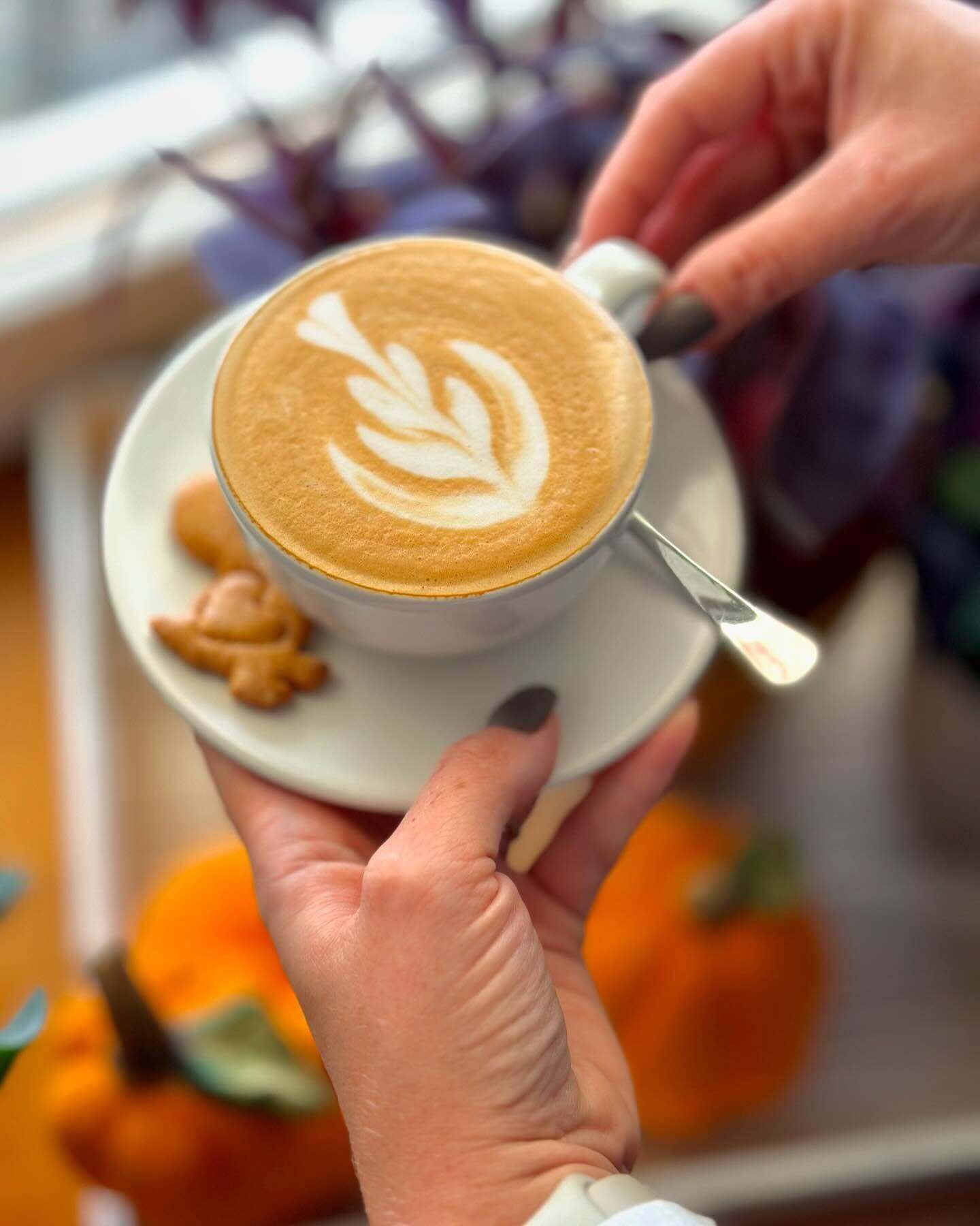 A cup of coffee with latte art on a saucer.