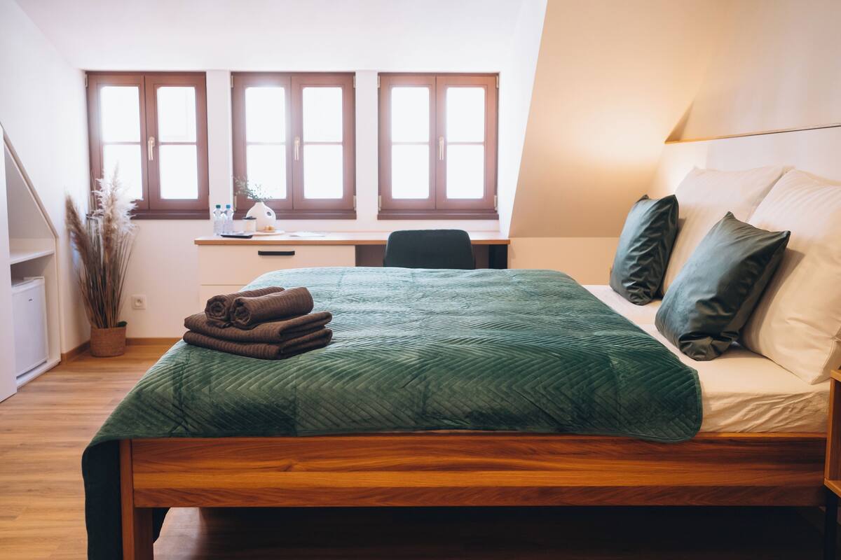 Une chambre à coucher avec un lit, un bureau et une fenêtre.