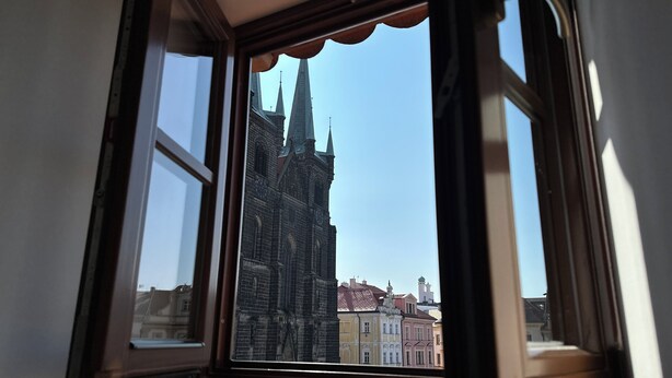 A window with a view of a historic building with multiple spires. - Penzion Tlustá kachna  (Chrudim)