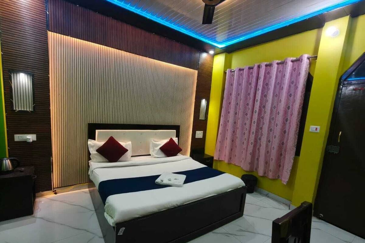 Een moderne slaapkamer met een bed, nachtkastjes en een gordijn.