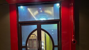 Une entrée d’immeuble avec une porte en verre et un cadre en métal.