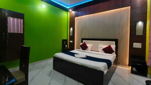 Une chambre d’hôtel moderne avec un lit, un ventilateur de plafond et un mur vert.