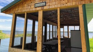 A wooden dockhouse with a sign reading "DOCKHOUSE" and a view of the water. - The Westender Retreat | Amazing Lake Views & Waterfront Dock House (Hessel)