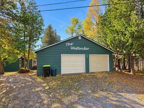 Un bâtiment écologique, baptisé « The Westender », doté de deux portes de garage, entouré d’arbres et jonché de feuilles mortes.