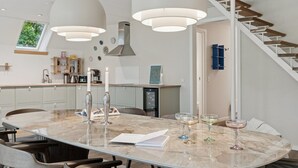 A modern kitchen with a large island, pendant lights, and a staircase. - "Estefania" - 1km from the sea by Interhome (Vejby)