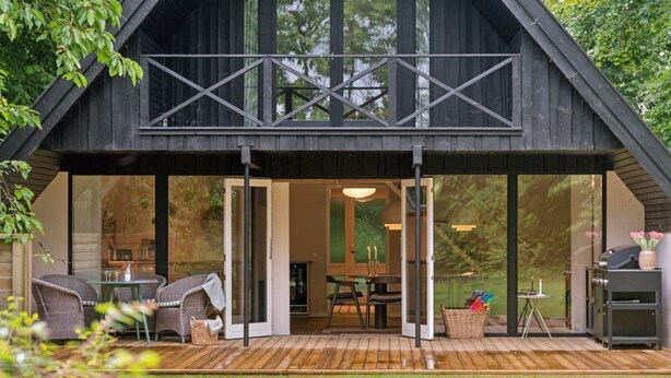 A modern wooden cabin with a covered patio, large windows, and a dining area. - "Estefania" - 1km from the sea by Interhome (Vejby)