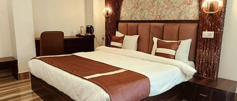 A modern hotel room with a large bed, a desk, and a chair.