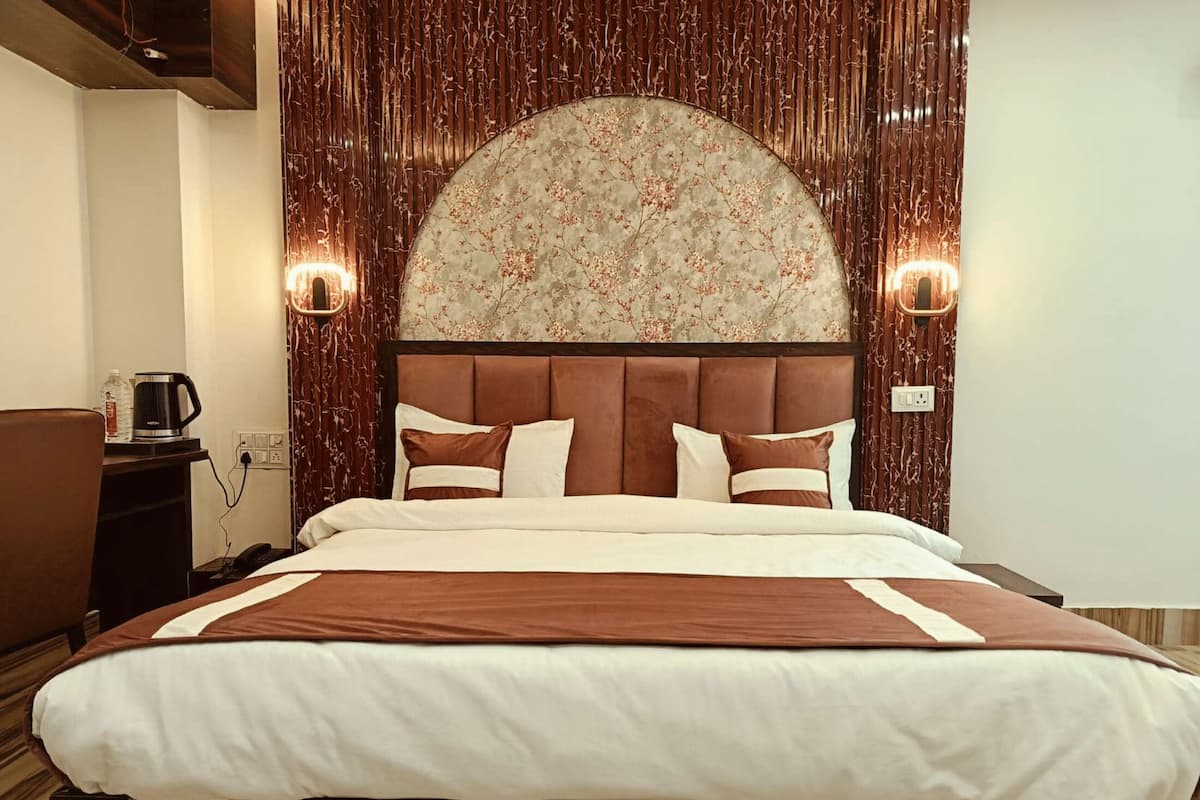 Una camera d'albergo con un letto grande, una testiera in legno e un pannello decorativo a parete.