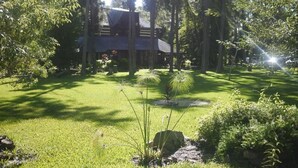 Una casa rodeada de un césped cuidado y árboles.