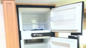 An open refrigerator with multiple shelves and a freezer compartment.