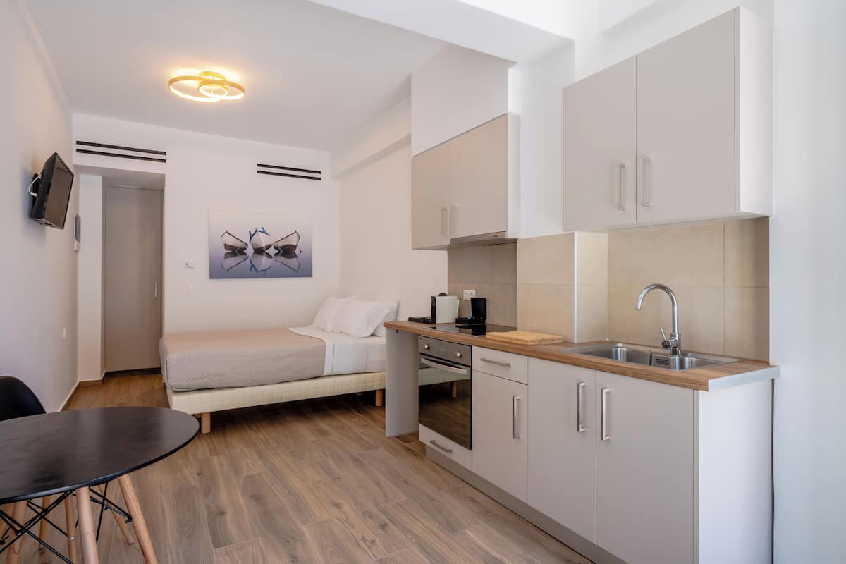 A compact kitchen with a built-in oven, a sink, and a dining area with a table.