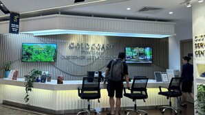 A customer service center with a reception desk, chairs, a TV screen, and a sign indicating customer service. - Gold Coast Mall Nha Trang - LT housing (Nha Trang)