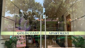 A hotel entrance with glass doors labeled "GOLDCOAST APARTMENT". - Gold Coast Mall Nha Trang - LT housing (Nha Trang)