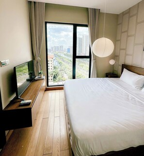 Enjoy a city view from the comfort of this stylish room, featuring a large bed, nightstand, and TV.