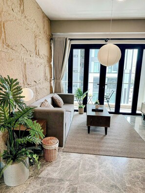Relax in this stylish living room with a sofa, coffee table, and lush greenery.