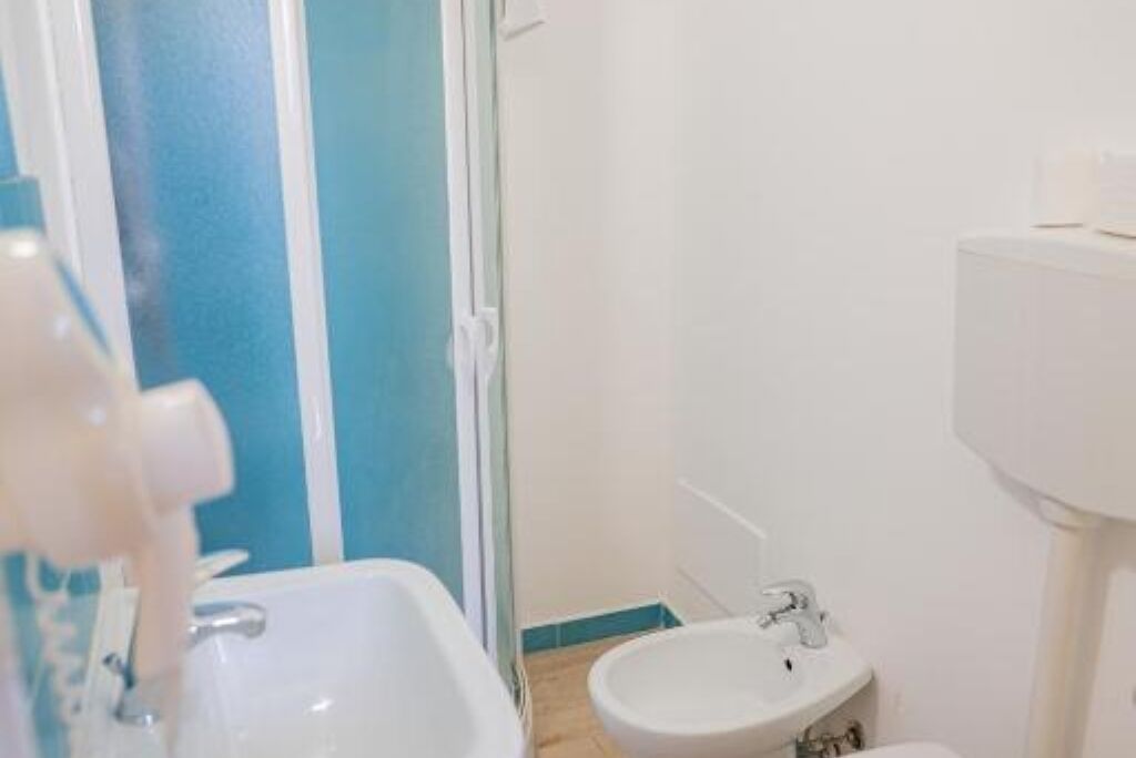 A bathroom with a sink, bidet, and toilet.