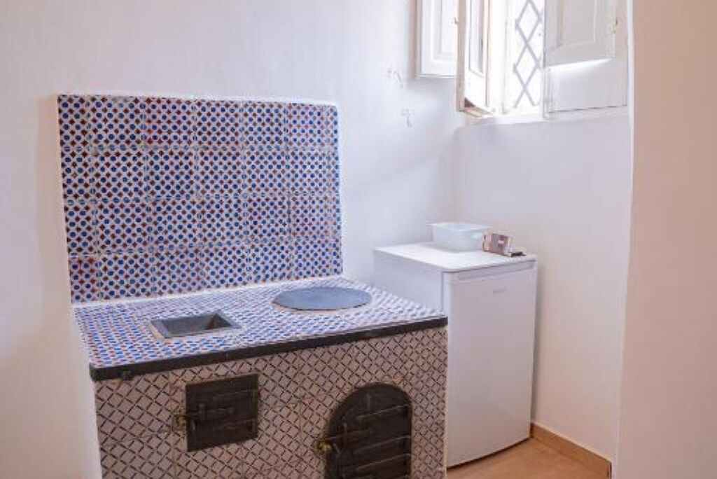 Une cuisine de taille réduite, dotée d’un plan de travail décoré, d’un évier et d’un lave-vaisselle.