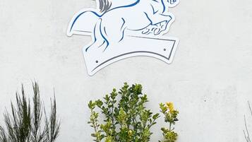 Un muro con un elemento decorativo bianco raffigurante un cavallo blu.