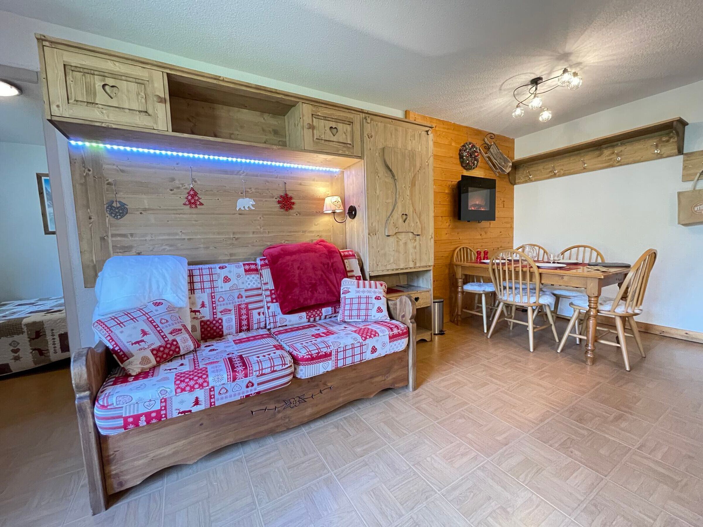 Um quarto acolhedor com um sofá de madeira, uma mesa de jantar com cadeiras e uma lareira.