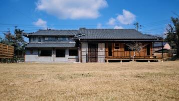 A traditional Japanese house with a tiled roof and a wooden structure in the front.