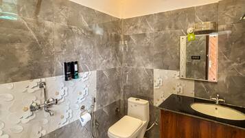 A modern bathroom with a toilet, shower, and sink.
