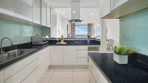 Een moderne keuken met een zwart aanrecht, een roestvrijstalen spoelbak en een magnetron.