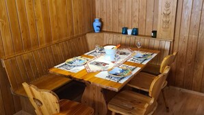 Un comedor de madera con una mesa dispuesta para cuatro personas, rodeada de sillas de madera.