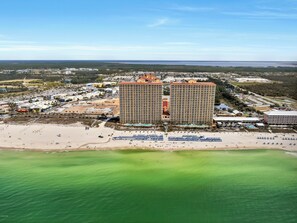 Un hôtel situé sur la côte, composé de plusieurs immeubles de grande hauteur, doté d’une plage de sable et d’un port de plaisance.