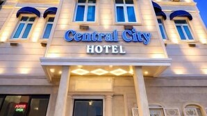 A hotel with a prominent sign reading 'Central City Hotel,' large windows, and a classical architectural style.