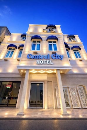 A hotel with a prominent sign reading 'Central City Hotel,' large windows, and a classical architectural style. - Central City Department Hotel (Baku)