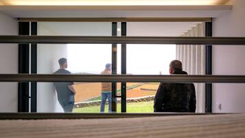 Ein modernes Interieur mit einem großen Fenster mit Blick auf eine gestaltete Grünfläche.