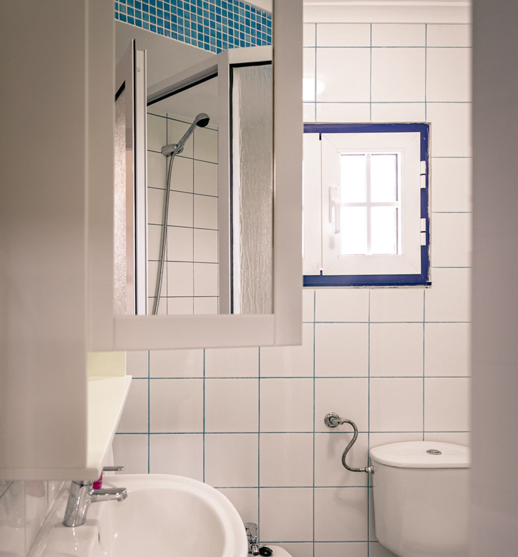 A bathroom with a white sink, a shower, and a toilet.