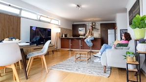 A modern living room with a dining area, a kitchen, and a large window. - Olis House in Angra do Hero smo (Angra do Heroismo)
