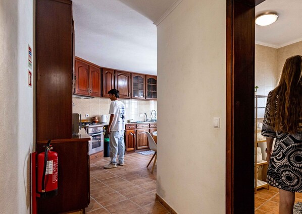 Une cuisine avec des meubles de rangement en bois, une cuisinière et un évier.