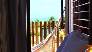 Una habitación con cama, una hamaca y vista al océano.