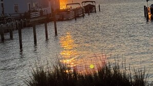 A waterfront property with a dock, a house, and a boat. - 1st Floor Direct Bayfront 1 bedroom Updated Condo with pool overlooking the bay! (Ocean City)
