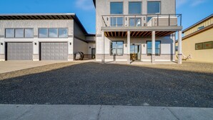 Un bâtiment moderne à deux étages, doté d’un garage, d’un espace extérieur couvert et d’un balcon.