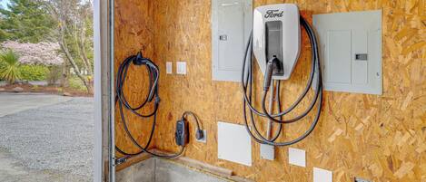 An electrical panel with a Ford charger and a power outlet on a wooden wall.