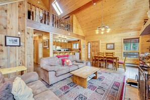 A spacious wooden cabin with a loft bedroom, a cozy living area with a sofa and coffee table, and a dining area with chairs. - 4 Mi to Rmnp: Allenspark Cabin w/ Wraparound Deck! (Allenspark)
