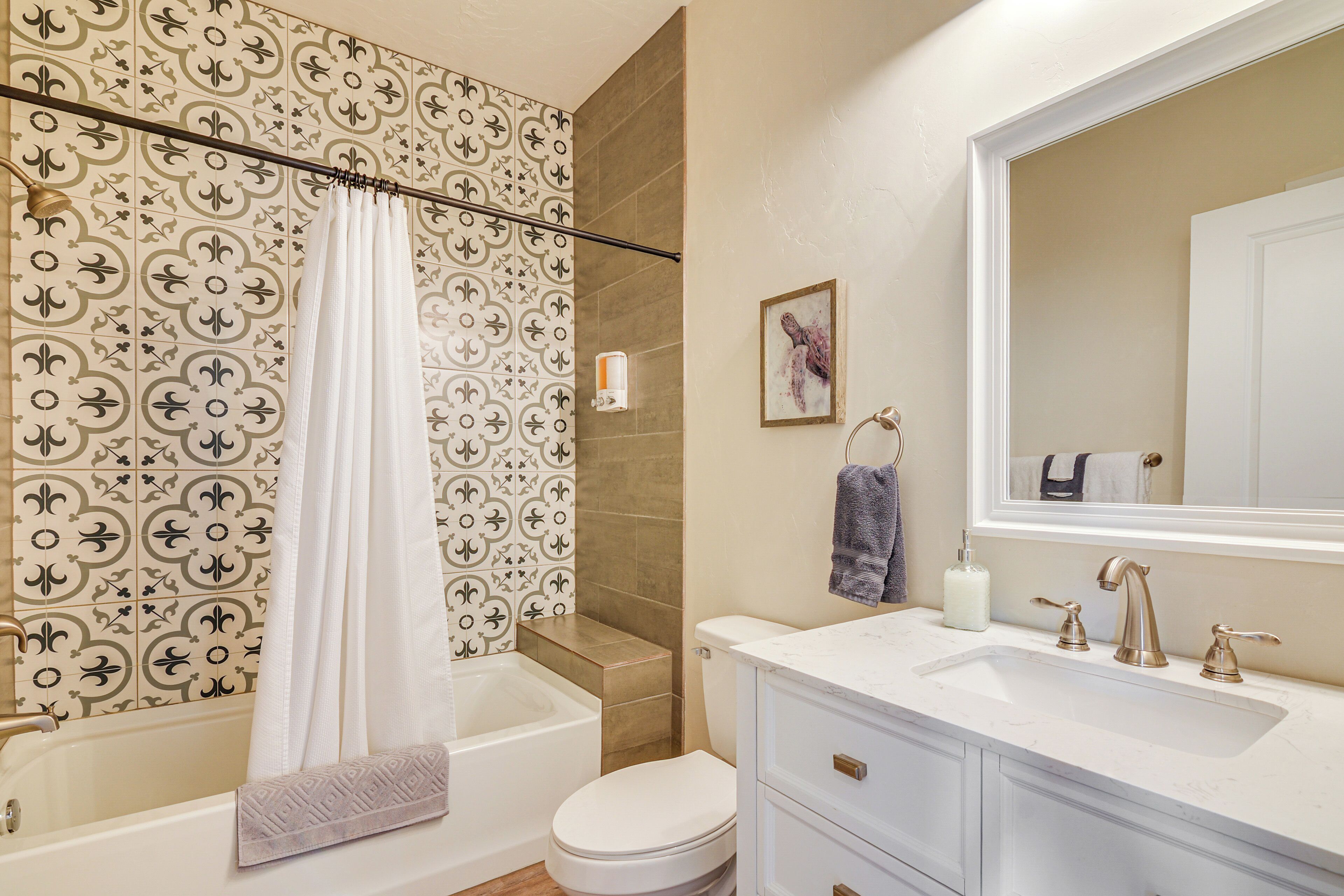 A bathroom with a bathtub, toilet, and sink.