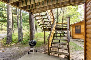 A wooden staircase leading to a cabin, surrounded by trees.